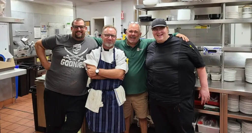 Jim Case from Pebble Creek Produce with chefs from gourmet restaurants standing in a kitchen who have partnered with Pebble Creek for mushrooms, gourmet microgreens and restaurant support.